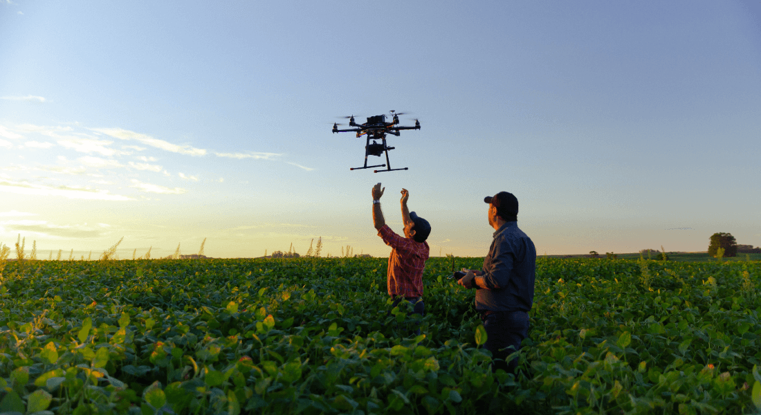 to mennesker sender en drone op på en mark